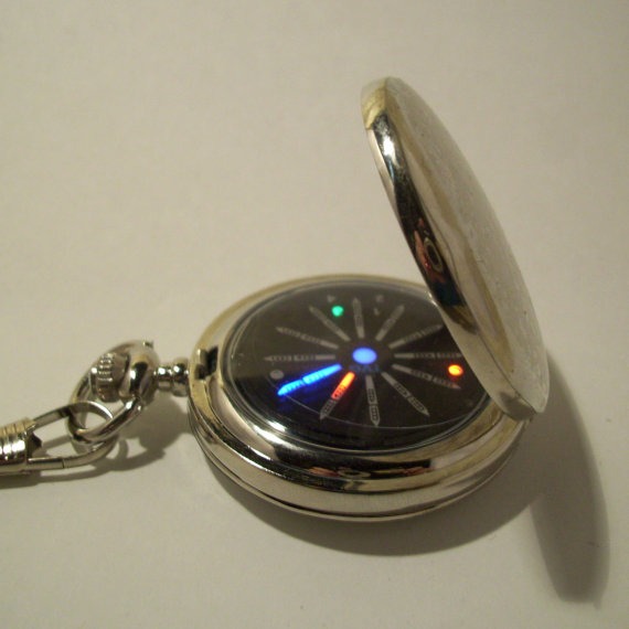 Small silver pocket watch with a glowing blue, red and green display. Traditional with a science fiction, steampunk twist. steampunk buy now online